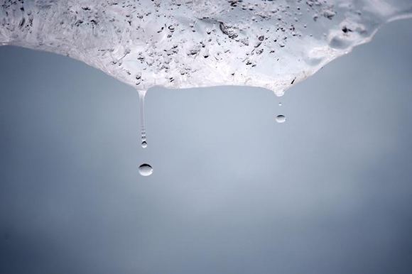 Droplets of water fall from a melting ice block harvested from Greenland and installed on Place du Pantheon for a project called Ice Watch Paris, in Paris, France. Photo by Benoit Tessier