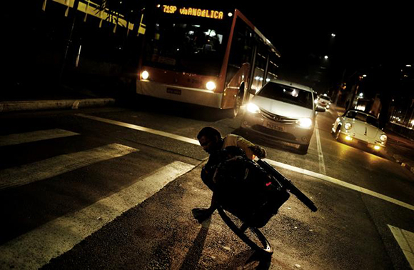 Elias, 43, nicknamed LA, who has polio, performs a dance with his wheelchair at a traffic light in the Paulista Avenue in Sao Paulo, Brazil. Photo by Nacho Doce