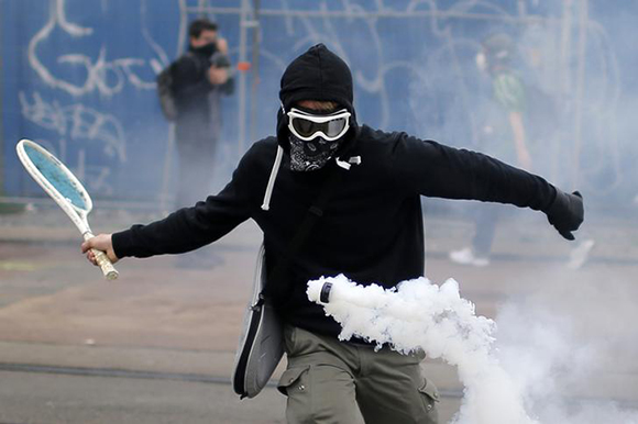 A protestor uses a tennis racket to return a tear gas canister during a demonstration to protest the government's proposed labour law reforms in Nantes, France Photo by Stephane Mahe
