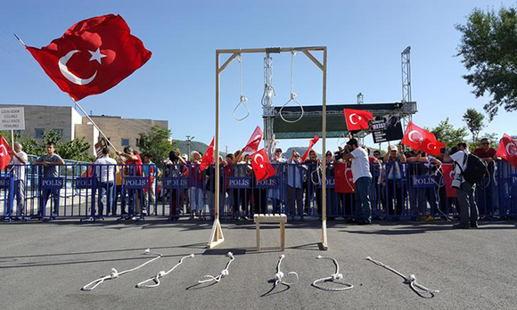 Supporters of President Tayyip Erdogan wave Turkish flags during a trial for soldiers accused of attempting to assassinate the president on the night of the failed last year's July 15 coup, in Mugla, Turkey Photo by Kenan Gurbuz