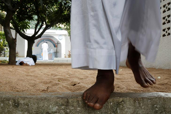 A member of the Celestial Church of Christ walks before the worship in the yard of their church in Abidjan, Ivory Coast. Photo by Luc Gnago