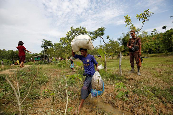 A Rohingya man returns to the No Man’s Land, with his belongings, from a makeshift shelter near the Bangladesh-Myanmar border, as the members of Border Guards Bangladesh (BGB) decided to push them back, in Cox’s Bazar, Bangladesh August 28, 2017. Photo by Mohammad Ponir Hossain