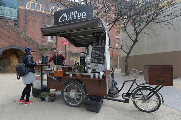 Barista Ondrej Kaluzay serves up a coffee from his mobile coffee shop named Brudo's Coffee based on a tricycle in Sydney, Australia. Photo by Jason Reed