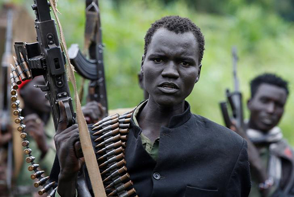SPLA-IO (SPLA-In Opposition) rebels hold up guns in Yondu, the day before an assault on government SPLA (Sudan People's Liberation Army) soldiers in the town of Kaya, on the border with Uganda, South Sudan. Photo by Siegfried Modola