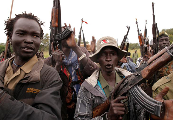 SPLA-IO (SPLA-In Opposition) rebels hold up guns in Yondu, the day before an assault on government SPLA (Sudan People's Liberation Army) soldiers in the town of Kaya, on the border with Uganda, South Sudan. Photo by Goran Tomasevic