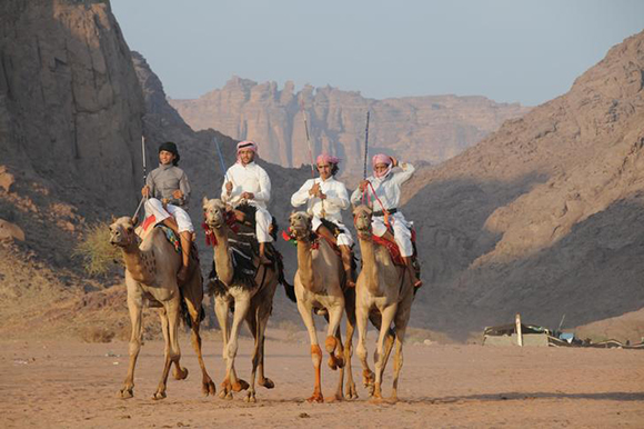 Saudi people ride camels as they celebrate the Muslim holiday of Eid Al-Adha in a desert in Tabuk, Saudi Arabia. Photo by Mohamed Al Hwaity