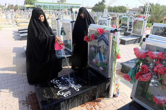 A woman pours water onto a grave at the "Valley of Peace" cemetery during the Muslim festival of Eid al-Adha in Najaf, Iraq September 3, 2017. Photo by Alaa Al-Marjani Photo by Valentyn Ogirenko