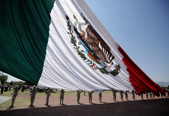 Soldiers hold a giant national flag as it raised during preparations for the 207th anniversary of Mexico's independence from Spain. Ciudad Juarez, Mexico. Photo by Jose Luis Gonzalez