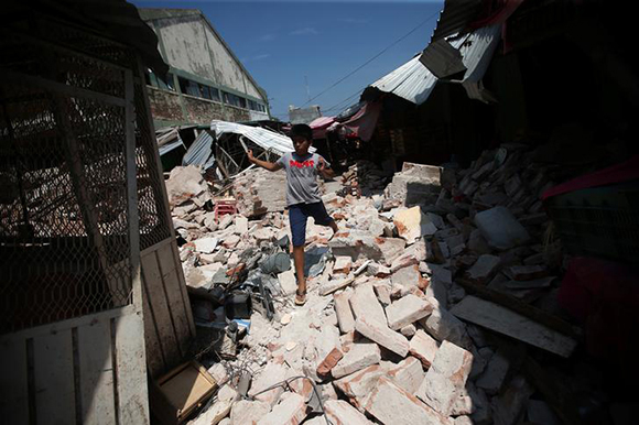 A boy walks on debris in the city of Juchitan, after an earthquake struck on the southern coast of Mexico late on Thursday, Mexico, September 9, 2017. REUTERS/Edgard Garrido