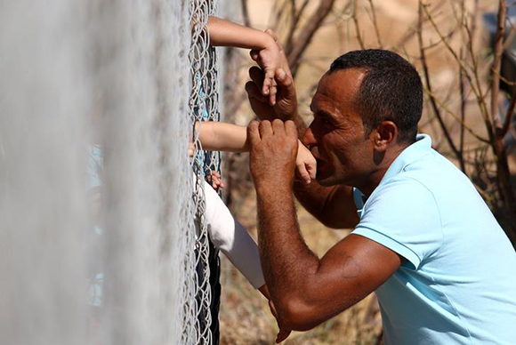 Ammar Hammasho from Syria who lives in Cyprus kisses his children who arrived at the refugee camp in Kokkinotrimithia outside Nicosia, Cyprus September 10, 2017. REUTERS/Yiannis Kourtoglou TPX IMAGES OF THE DAY