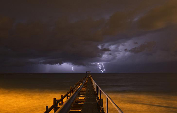 Lightning strikes over a pier during a storm in Atlit, near the northern Israeli city of Haifa. Photo by Baz Ratner