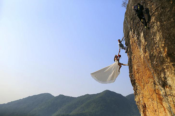  Zheng Feng, an amateur climber takes wedding pictures with his bride on a cliff in Jinhua, Zhejiang province, Photo by China Daily 