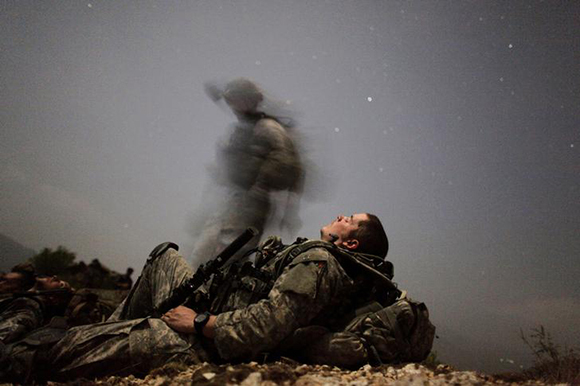  A U.S. soldier of 2-12 Infantry 4BCT-4ID Task Force Mountain Warrior takes a break during a night mission near Honaker Miracle camp at the Pesh valley of Kunar Province. Photo by Carlos Barria 