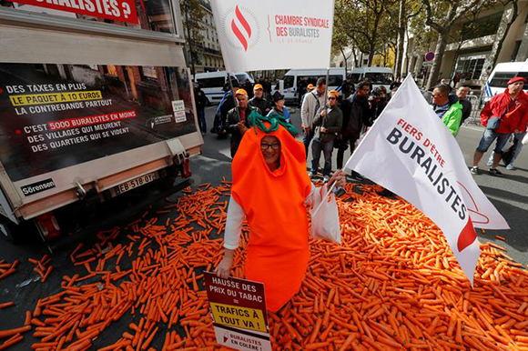 A French tobacconist dressed as a giant carrot attends a demonstration near the Health Ministry to protest the government's policy to gradually increase the price of cigarettes packets in Paris, France, October 4, 2017. Photo by Philippe Wojazer