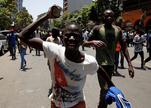 A supporter of the opposition National Super Alliance (NASA) coalition holds up a stone during a protest calling for the sacking of election board officials involved in August's cancelled presidential vote, in Nairobi, Kenya October 6, 2017. Photo by Baz Ratner 