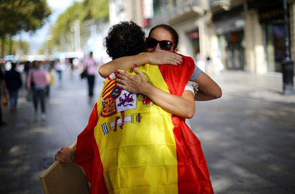 A man wearing a Spanish flag gives "free hugs" in central Barcelona, Spain, October 9, 2017. Photo by Ivan Alvarado 