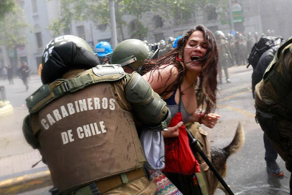 A demonstrator is detained by riot police during a rally against Columbus Day in downtown Santiago, Chile, October 9, 2017. Photo by Pablo Sanhueza 