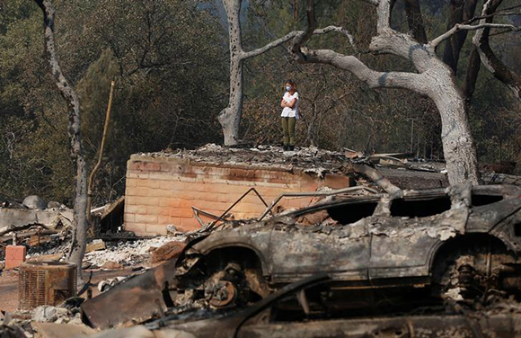  Pamela Garibaldi looks over burned remains of her parents home destroyed by wildfire in Napa, California, U.S., October 13, 2017. Photo by Jim Urquhart 