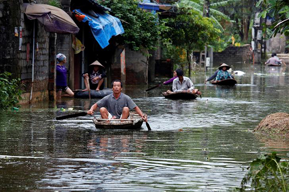  Residents paddle boats, in a flooded village, after heavy rain, caused by a tropical depression in Hanoi, Vietnam October 17, 2017. Photo by Kham 