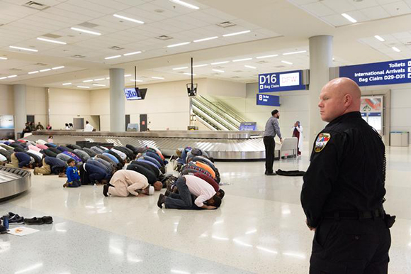 People gather to pray in baggage claim during a protest against the travel ban imposed by U.S. President Donald Trump's executive order, at Dallas/Fort Worth International Airport in Dallas, Texas, U.S. Photo by Laura Buckman 