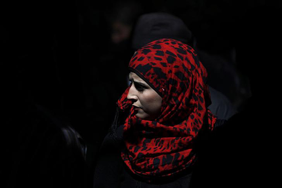 A Palestinian woman shops at a market before Friday prayers in Jerusalem's Old City. Photo by Amir Cohen 