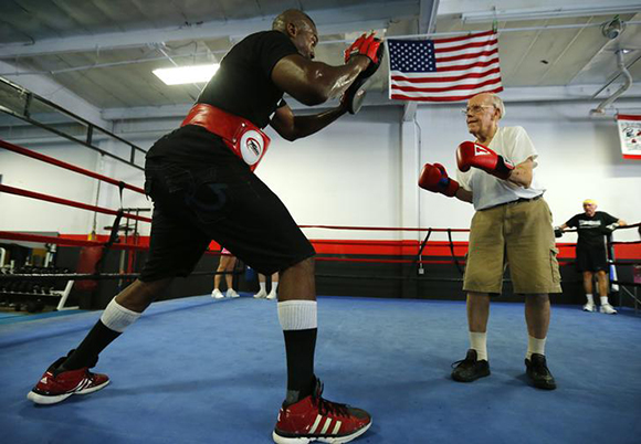 Parkinson's patient Jim Coppula works out in the ring with boxing coach Justice Smith (L) during his Rock Steady Boxing session in Costa Mesa, California. Photo by Mike Blake 