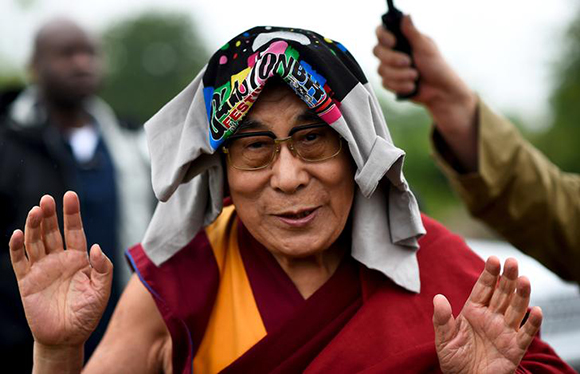 The Dalai Lama greets well-wishers before addressing a crowd gathered at the Stone Circles at Worthy Farm in Somerset during the Glastonbury Festival in Britain. Photo by Dylan Martinez