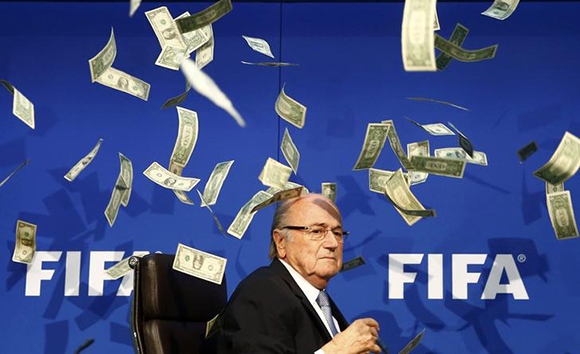British comedian known as Lee Nelson (unseen) throws banknotes at FIFA President Sepp Blatter as he arrives for a news conference after the Extraordinary FIFA Executive Committee Meeting at the FIFA headquarters in Zurich, Switzerland. Photo by Arnd Wiegmann