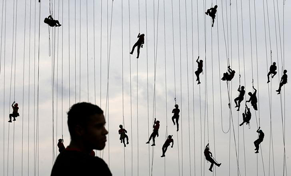  People climb after jumping off a bridge, which has a height of 30 meters, in Hortolandia, Brazil, October 22, 2017. According to organizers, 245 people were attempting set a new world record for "rope jumping", in which people, tied to a safety cord, jump off a bridge. Photo by Paulo Whitaker 