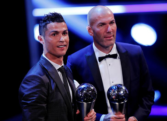  Soccer Football - The Best FIFA Football Awards - London Palladium, London, Britain - October 23, 2017 Real Madrid’s Cristiano Ronaldo celebrates after winning The Best FIFA Men’s Player Award with Real Madrid coach Zinedine Zidane. Photo by Eddie Keogh 