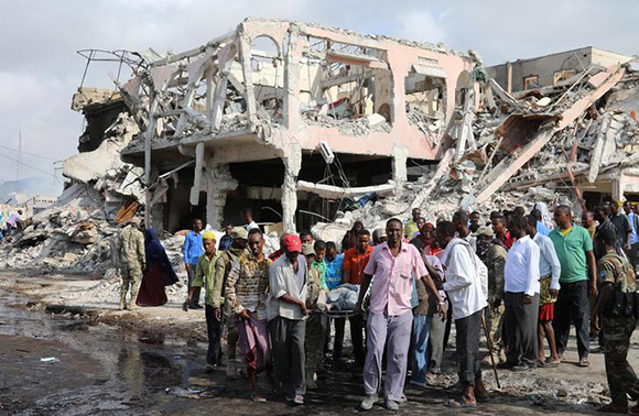  Civilians carry the body of an unidentified man from the scene of an explosion in KM4 street in the Hodan district of Mogadishu, Somalia. Photo by Feisal Omar 