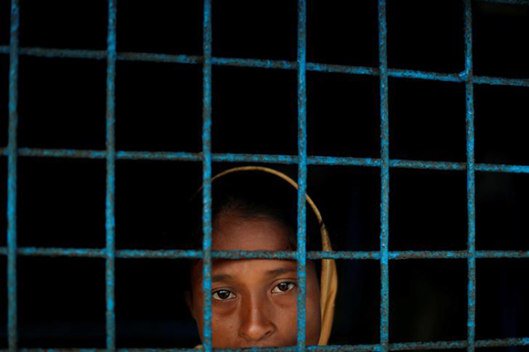  A Rohingya refugee who crossed the border from Myanmar this week stands at a window of a school used as a shelter at Kotupalang refugee camp near Cox's Bazar, Bangladesh. Photo by Jorge Silva 