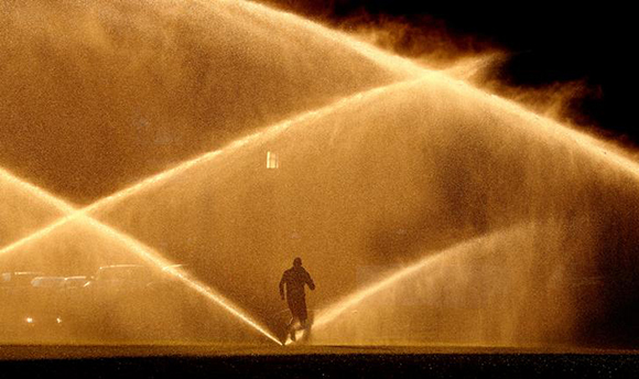  A jogger makes his way past sprinklers alight with the morning sun on a beautiful autumn day in Washington, U.S. Photo by Kevin Lamarque 