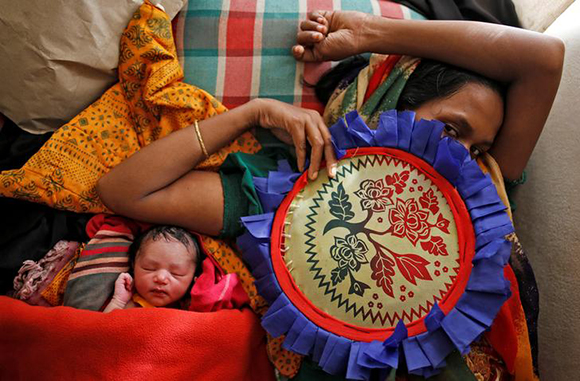  Zahida Begum, 22, lies on a bed with her newborn baby after her delivery at a medical centre in Kutupalong refugee camp near Cox's Bazar, Bangladesh October 28, 2017. Photo by Adnan Abidi 