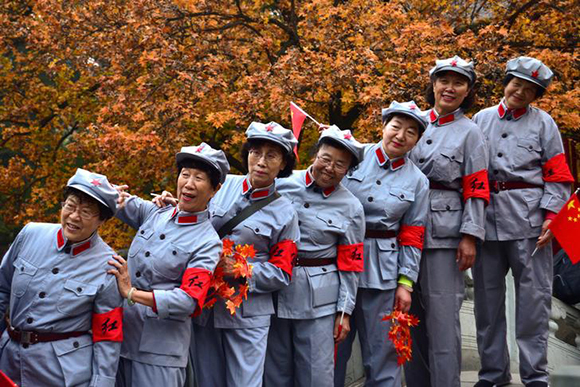  Women in replica red army uniforms have their picture taken as autumn leaves cover maple trees in Fragrant Hills Park in Beijing, China. Photo by Stringer 