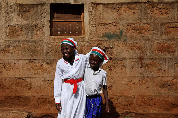  Girls smile at the beginning of a Sunday service outside of an African Divine Church near the slum area of Korogocho in the capital Nairobi, Kenya. Photo by Siegfried Modola 