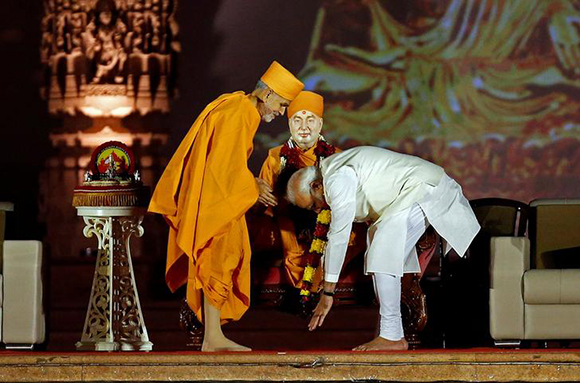  Indian Prime Minister Narendra Modi touches the feet of a saint during Akshardham temple's silver jubilee celebrations in Gandhinagar, India, November 2, 2017. Photo by Amit Dave 