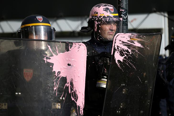 French CRS riot police are covered with paint as protestors clash with police forces during a demonstration against French government reforms in Nantes, France, November 16, 2017. Photo by Stephane Mahe