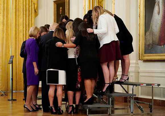  U.S. President Donald Trump prays with the Oklahoma Women's Softball women team as he greets members of Championship NCAA teams at the White House in Washington, U.S., November 17, 2017. Photo by Joshua Roberts 