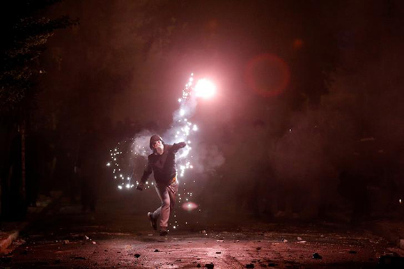  A hooded protester throws a flare during clashes following a rally marking the 44th anniversary of a 1973 student uprising against the military dictatorship that was ruling Greece, in Athens, Greece November 17, 2017. Photo by Alkis Konstantinidis 