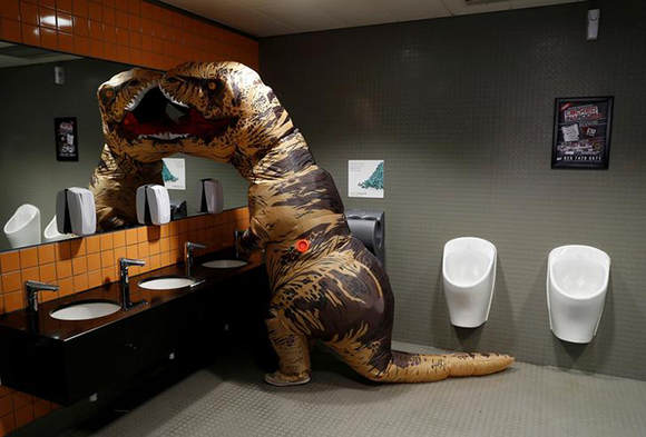  A visitor wearing a T-Rex costume uses the lavatory at the London Comic Con, at the ExCel exhibition centre in east London, Britain. Photo by Peter Nicholls 