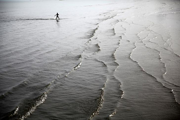  A boy runs in shallow water on a beach in the coastal city of Larnaca, Cyprus. Photo by Yiannis Kourtoglou 