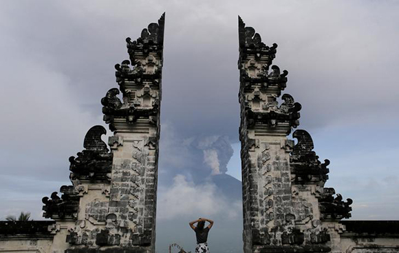  A tourist watches as Mount Agung volcano erupts at Lempuyang Temple in Karangasem, Bali, Indonesia. Photo by Johannes P. Christo 