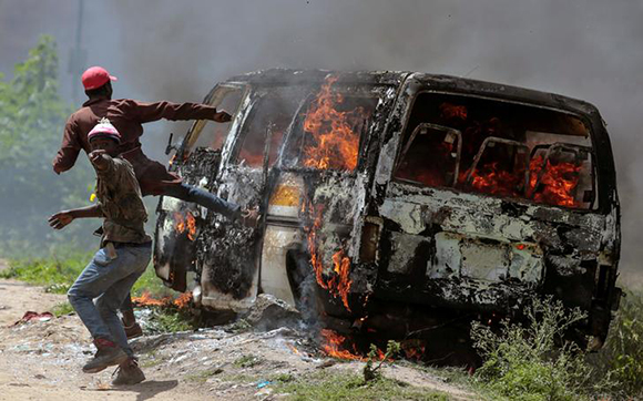  Supporters of Kenyan opposition National Super Alliance (NASA) gesture near a burning vehicle in Embakasi, on the outskirts of Nairobi, Kenya November 28, 2017. Photo by Stringer 