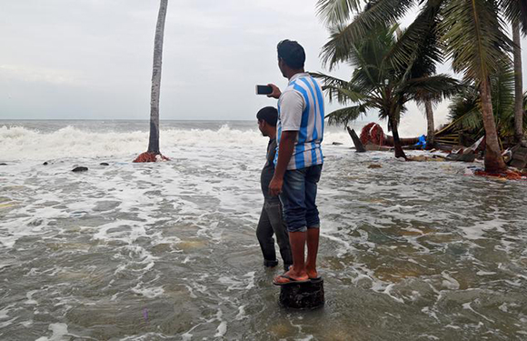  A man uses his mobile phone to take photographs of tides on the shores of the Arabian Sea, after flooding caused by Cyclone Ockhi in the coastal village of Chellanam in the southern state of Kerala, India, December 2, 2017. Photo by Sivaram V 