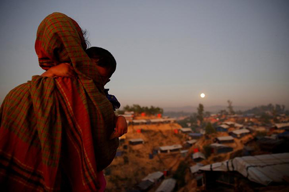  A Rohingya refugee looks at the full moon with a child in tow at Balukhali refugee camp near Cox's Bazar, Bangladesh, December 3, 2017. Photo by Susana Vera 