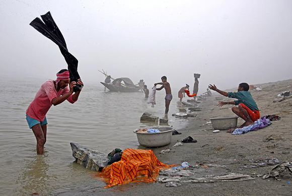  People wash clothes on the banks of the river Brahmaputra on a foggy winter morning in Guwahati, India, December 4, 2017. Photo by Anuwar Hazarika 