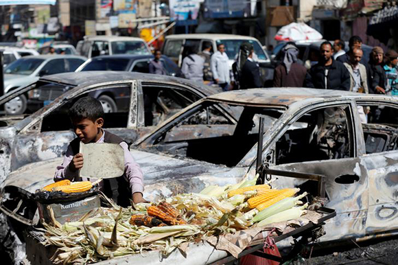  A boy sells grilled corn near cars damaged during recent clashes between Houthi fighters and forces loyal to Yemen's former president Ali Abdullah Saleh in Sanaa, Yemen December 5, 2017. Photo by Khaled Abdullah 