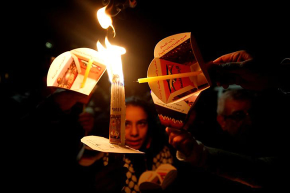 Christian protesters light candles as they take part in a march to protest U.S. President Donald Trump's recognition of Jerusalem as Israel's capital, in Amman, Jordan December 13, 2017. Photo by Muhammad Hamed 