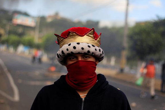  A hooded opposition supporter poses for a picture during a protest over a disputed presidential election in Tegucigalpa, Honduras December 15, 2017. Photo by Jorge Cabrera 